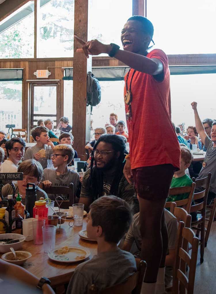 Camp counselor with campers at lunch