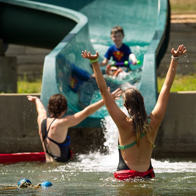 Counselors and campers going down a water slide